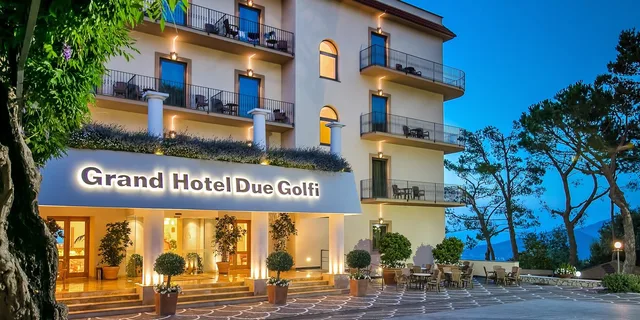Ingresso del Grand Hotel Due Golfi di sera, con l'insegna illuminata e la terrazza