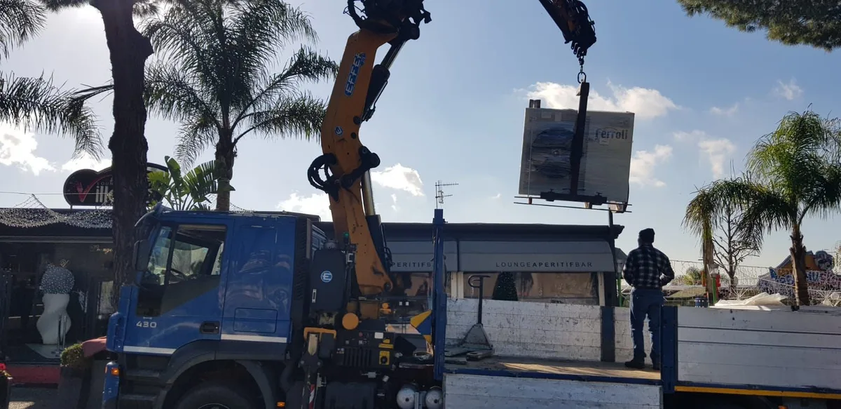 Autocarro con gru per la movimentazione di gruppi frigo