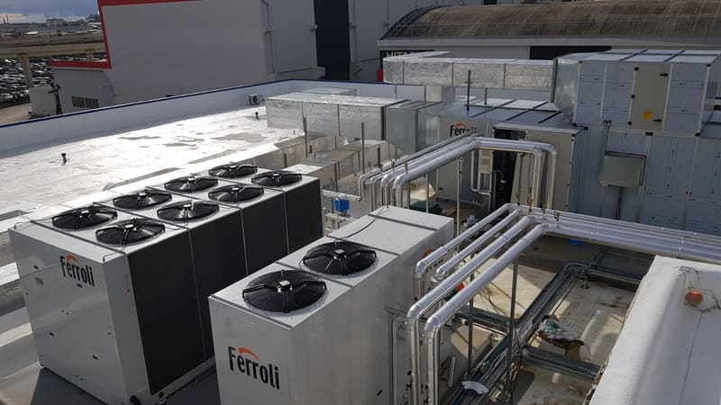 Tecnici Condass al lavoro su unità chiller Ferroli installate su tetto industriale